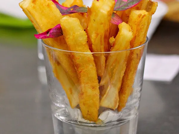 Yucas fritas servidas en vaso con salsa huancaína